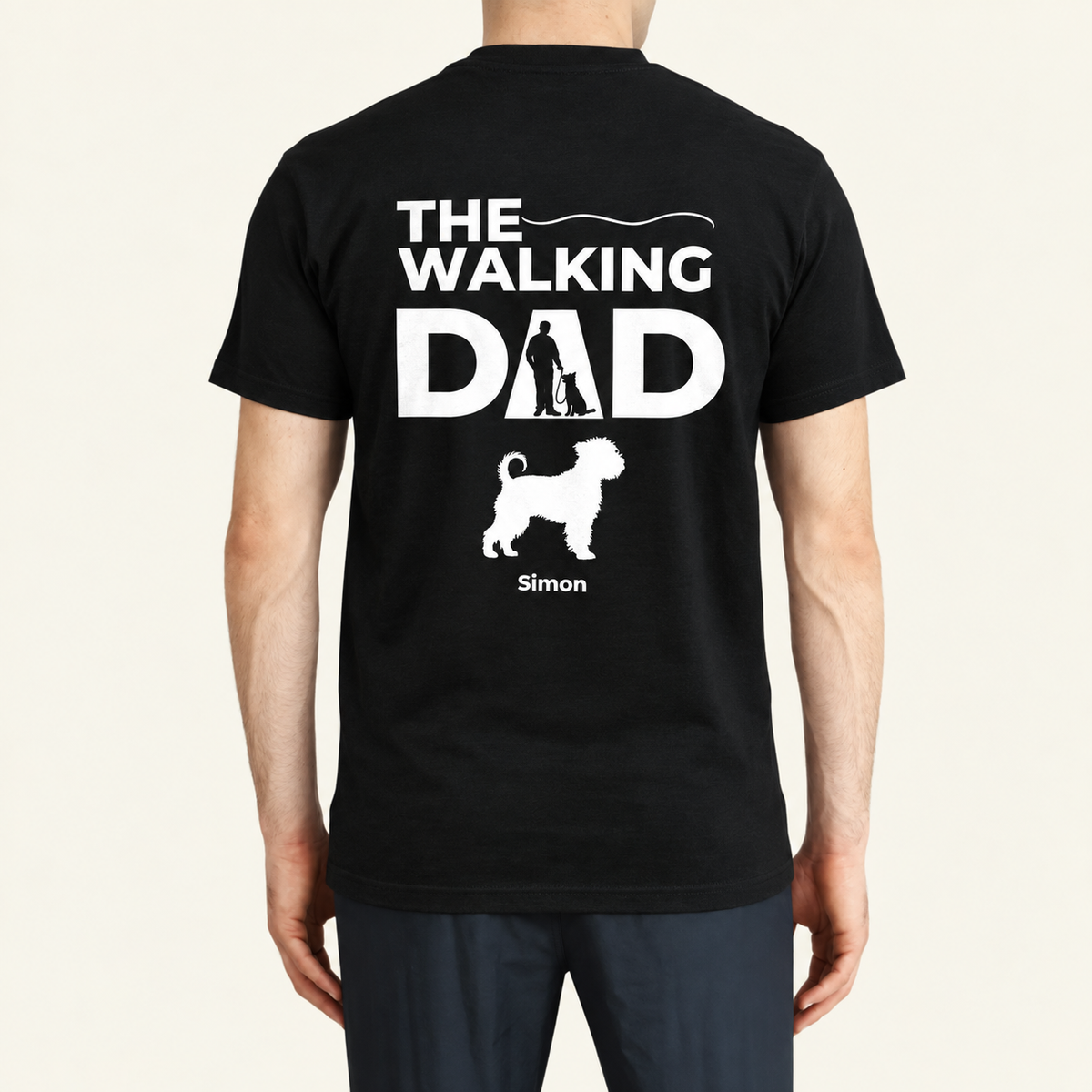 T-shirt noir avec l'inscription "THE WALKING DAD" et une silhouette de promenade avec chien. Personnalisé avec le nom Simon.