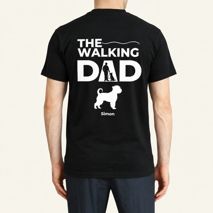 T-shirt noir avec l'inscription "THE WALKING DAD" et une silhouette de promenade avec chien. Personnalisé avec le nom Simon.