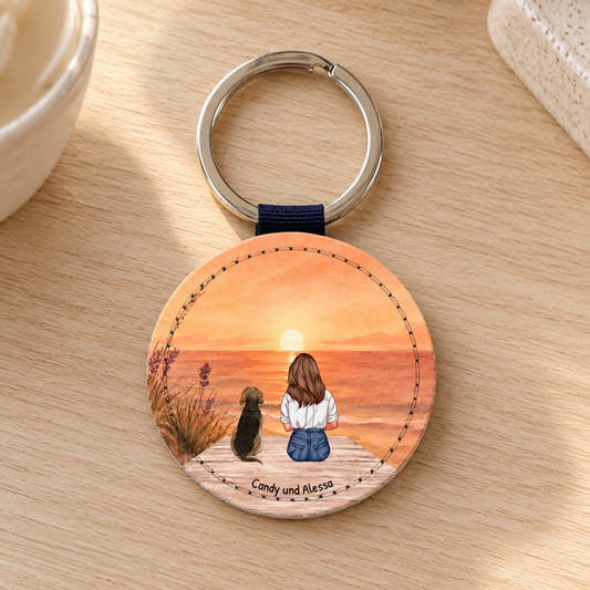 Porte-clés rond personnalisé avec illustration d'une femme et d'un chien au coucher du soleil.
