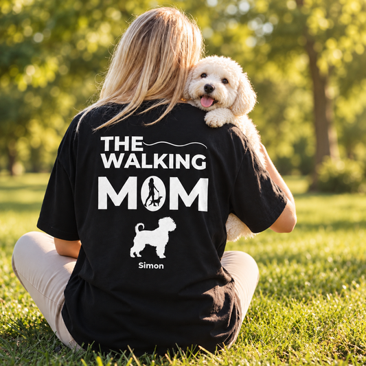 T-shirt noir personnalisé avec l'inscription "THE WALKING MOM" et motif de chien. La personne est assise dehors.