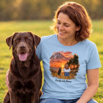 T-shirt bleu avec impression graphique d'une femme et de son chien devant un paysage de montagne.