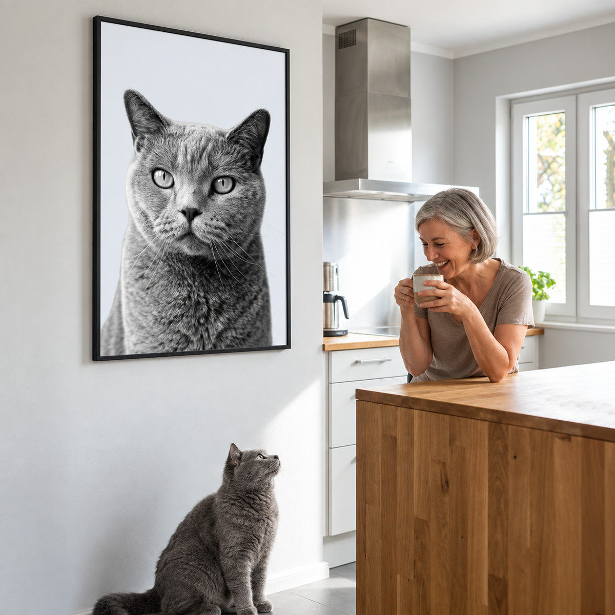 Personne souriante montrant un portrait personnalisé d'un chat gris au mur.