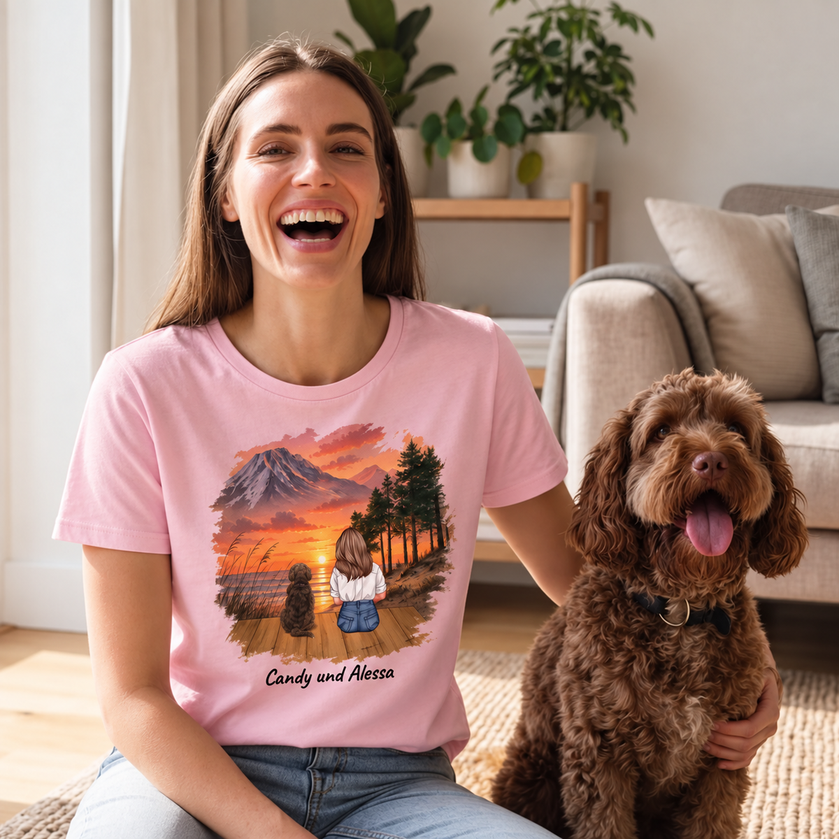T-shirt rose avec impression personnalisée d'une femme et de deux chiens devant un paysage au coucher du soleil.