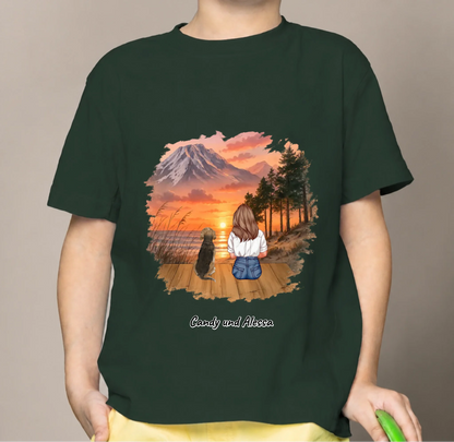 T-shirt enfant vert foncé avec imprimé coloré d'une fille et d'un chien au coucher du soleil.