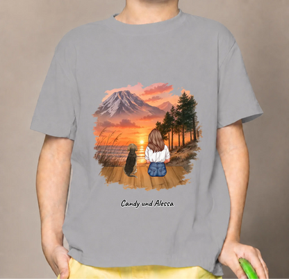 T-shirt enfant gris avec graphique d'une personne assise et d'un chien au coucher du soleil.