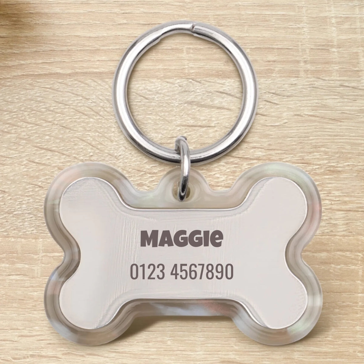 Médaille pour chien en époxy personnalisée en forme d'os avec le nom "Maggie" et un numéro de téléphone.