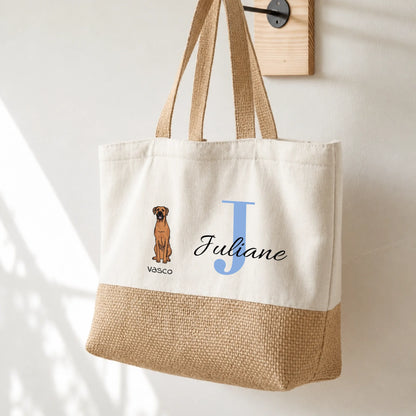 Sac cabas beige avec anses, personnalisé avec l'initiale “J” et une image de chien. Partie inférieure en jute.