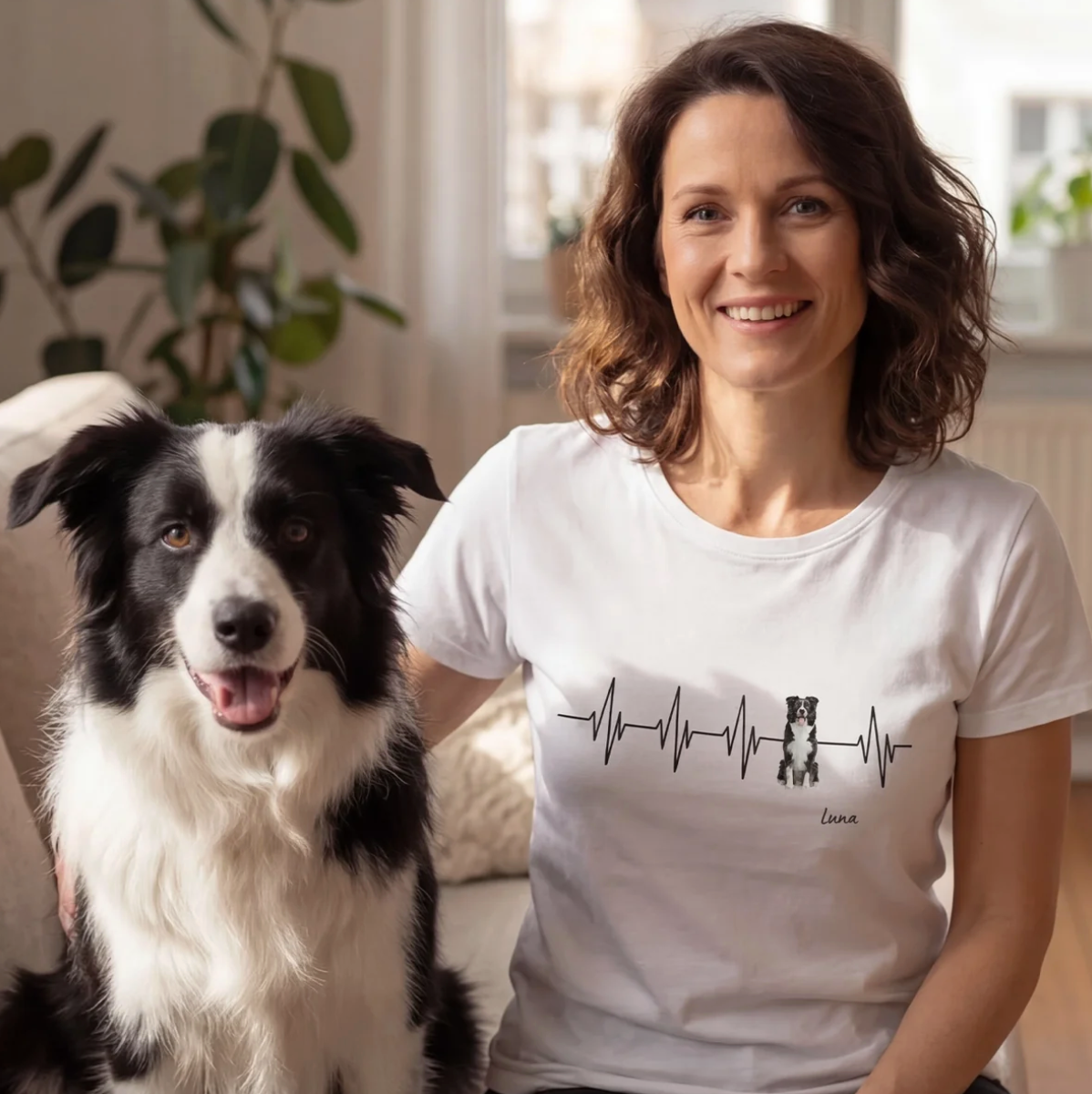 T-shirt blanc avec design battement de cœur et motif de chien, personnalisable. Femme assise sur un canapé avec un chien.