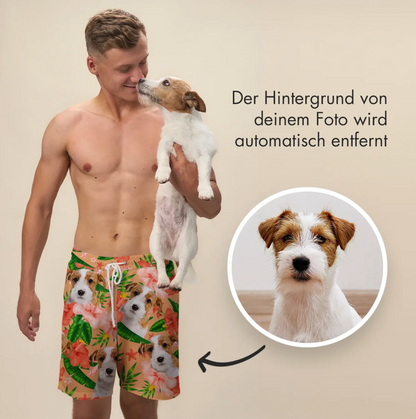 Homme en short de bain court imprimé de chiens et de fleurs, tenant un chien dans ses bras.