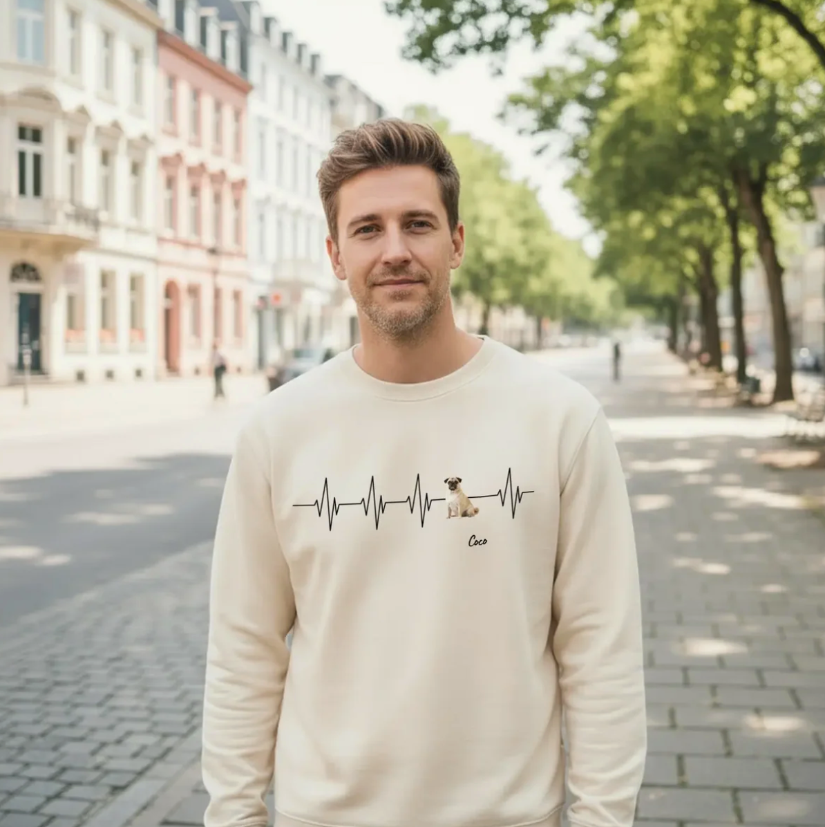 Sweat-shirt beige avec motif battement de cœur et chien, porté par un homme en ville.