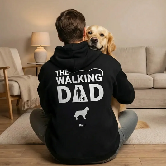Personne assise avec un chien sur les genoux, en sweat à capuche noir avec l'inscription "The Walking Dad".