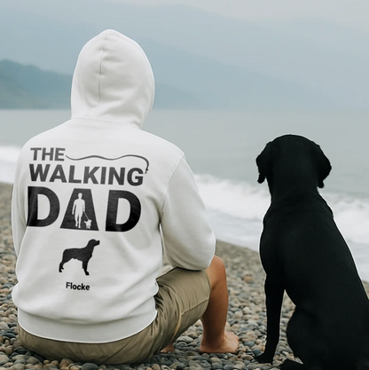 Sweat à capuche blanc avec impression dos "THE WALKING DAD" et motif de chien, porté par un homme assis sur la plage.