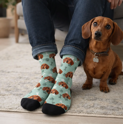 Chaussettes personnalisées vert menthe avec motif de chien et pied noir, portées par une personne. Chien assis à côté.