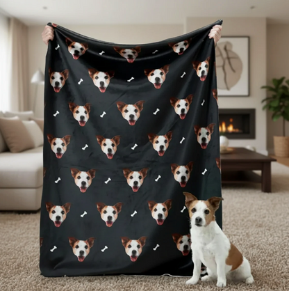 Couverture personnalisée avec têtes d'animaux sur fond noir, tenue par une personne avec un chien au premier plan.
