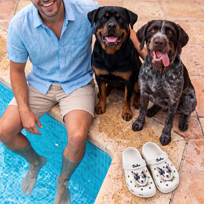 Sabots blancs personnalisés au design aquarelle, à côté d'un homme et de deux chiens au bord de la piscine.